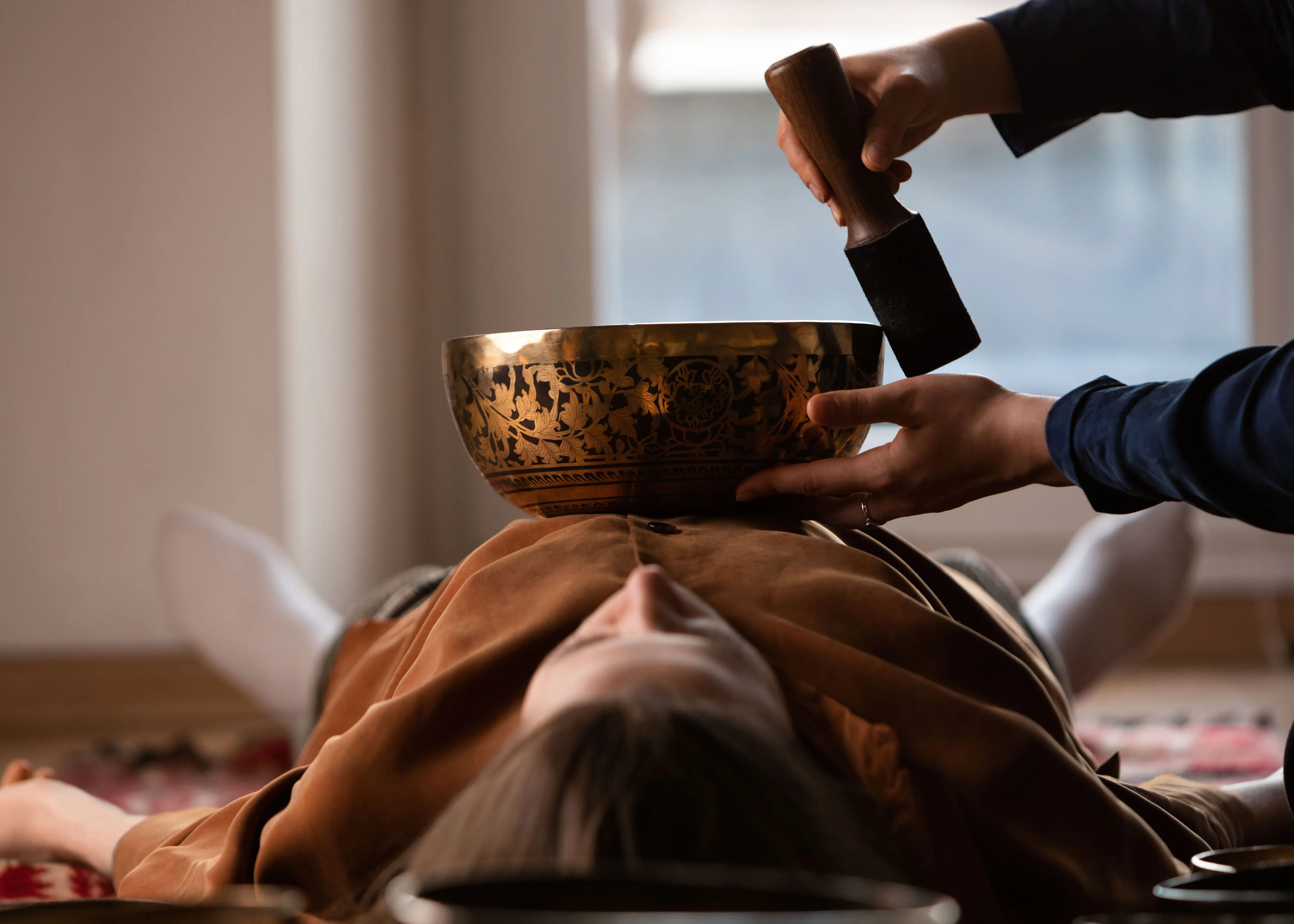 Tibetan singing bowls on a person's chest